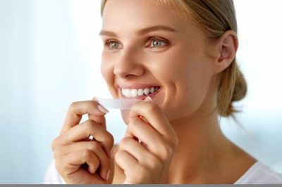 Woman Using a Teeth Whitening Strip